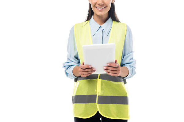 Cropped view of engineer in safety vest using digital tablet isolated on white