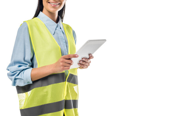 Cropped view of engineer in safety vest using digital tablet isolated on white
