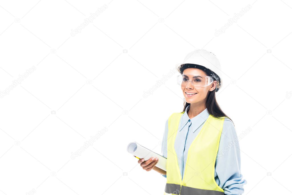 Smiling engineer in protective goggles holding blueprint isolated on white