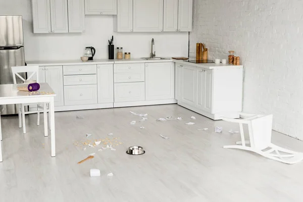 厨房内部 有金属碗 木勺和破碎的菜肴在地板上 — 图库照片