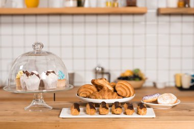 ay çöreği, kek, eklerleri ve macaroons kahve dükkanında olan sayaç bar ahşap