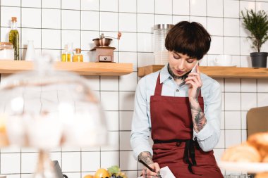 seçici odak oldukça, barista smartphone ile konuşurken konsantre