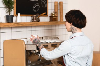 çekici dövmeli barista ayakta yakınındaki kafede espresso makinesi 