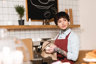 güzel barista fincan espresso makinesi yakın dururken silerek seçici odak