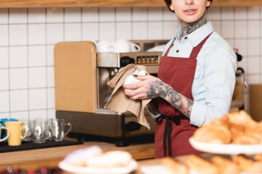 Kısmi Kupası kahve makinesi yakın dururken silerek barista görünümünü
