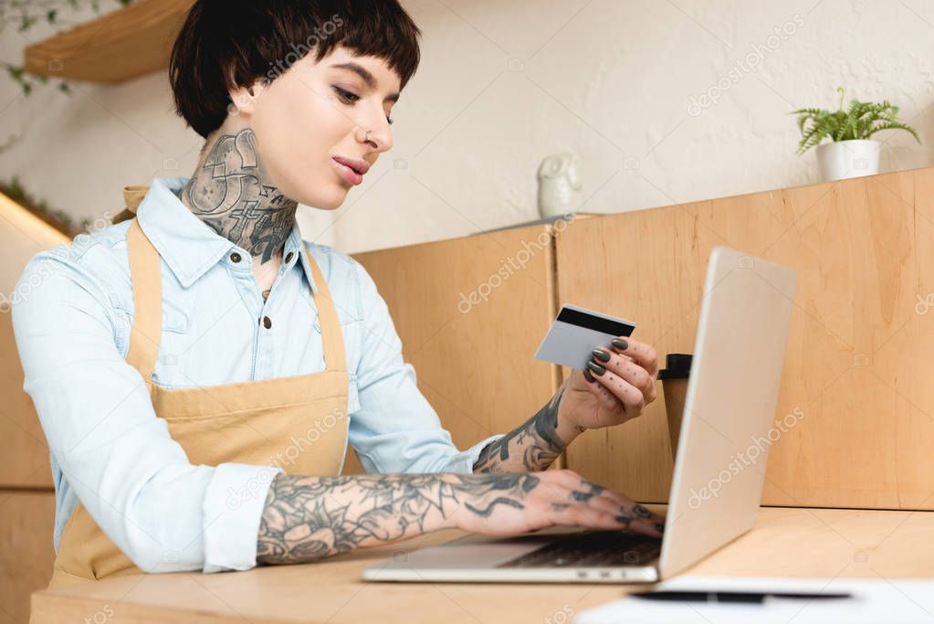 attractive waitress looking at credit card and writing in notebook