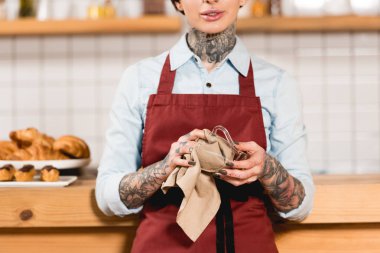 barista cam fincan bez ile silerek önlük kısmi görünümünü  