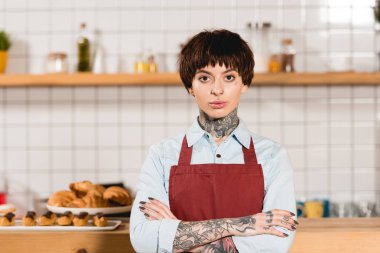 çapraz kolları ile ayakta ve kameraya bakarak güzel barista seçici odak