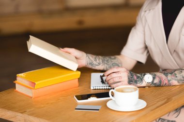 kitap, smartphone ve kahve fincanı masadan işkadını kısmi görünümünü 
