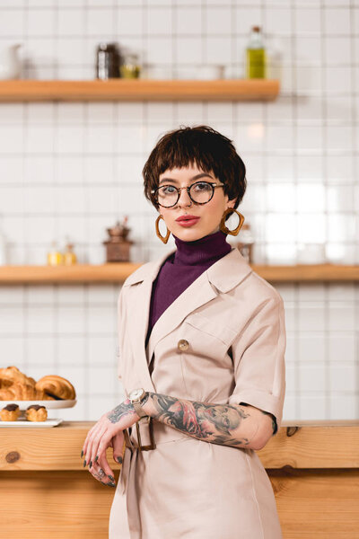 trendy, attractive businesswoman standing near bar counter in cafeteria