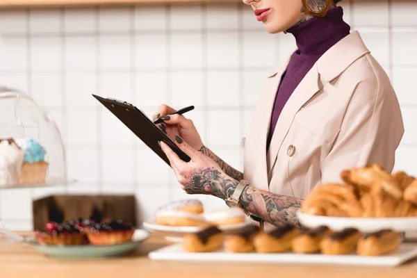 Gedeeltelijke Weergave Van Zakenvrouw Schrijven Klembord Cafetaria — Stockfoto