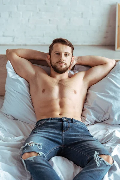 Güzel Kaslı Adam Yatakta Yatarken Kamera Yatak Odasında Bakarak Kot — Stok fotoğraf