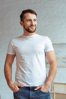 Beyaz t-shirt yakışıklı adam elleri ceplerinde uzağa arıyorsunuz 
