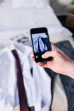 akıllı telefon ile yatak odası fotoğraf çekerken adam kısmi görünümü