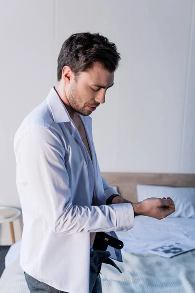 Vacker Sömnig Man Dressing Vit Skjorta Medan Står Nära Sängen — Stockfoto