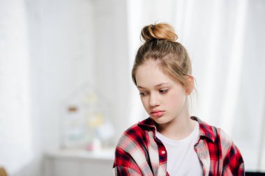 Pensive teenager kid in red checkered shirt looking away clipart