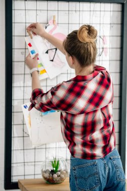 Pinboard üzerinde asılı damalı gömlek genç geri görünümü