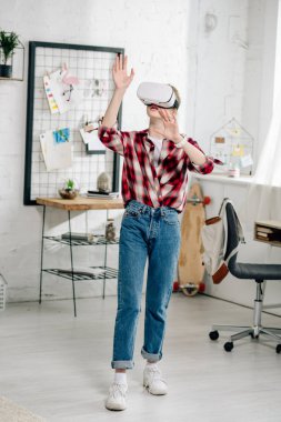 Evde Genç kırmızı damalı gömlek ve VR kulaklık tam uzunlukta görünümü