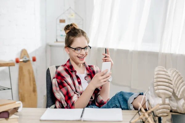 Smiling Teenager Glasses Sitting Legs Table Using Smartphone — Stock Photo, Image