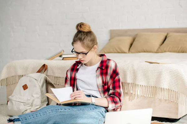 Adolescente Concentrado Óculos Livro Leitura Camisa Quadriculada Perto Cama — Fotografia de Stock