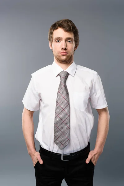 Seriöser Geschäftsmann Posiert Mit Händen Taschen Auf Grauem Hintergrund — Stockfoto