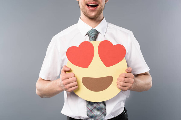 cropped view of excited businessman holding smiling face with heart-eyes