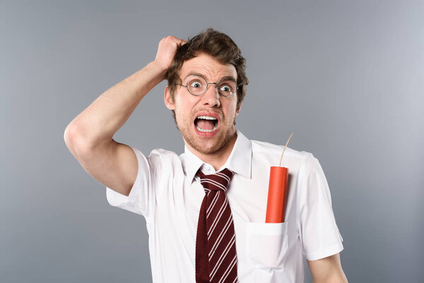 scared businessman in glasses screaming with dynamite in pocket