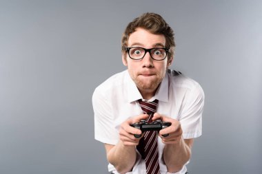 gri arka plan üzerinde joystick ile bilgisayar oyunu oynamak işadamı konsantre
