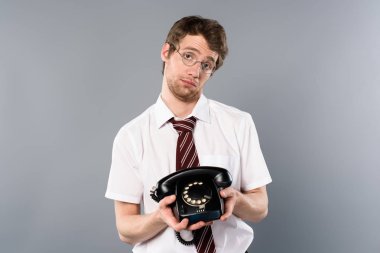 vintage telefon gri arka plan üzerinde tutarak bardaklarda üzgün işadamı