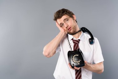 vintage telefon gri arka plan üzerinde tutarak bardaklarda yorgun işadamı