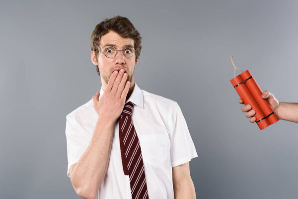 frightened man holding hand on mouth while another holding dynamite