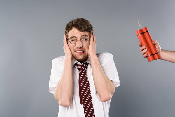 frightened man holding hands on ears while another holding dynamite