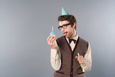 komik surat ifadesi cupcake ve parti boynuz holding ile gözlük ve parti şapkalı adam