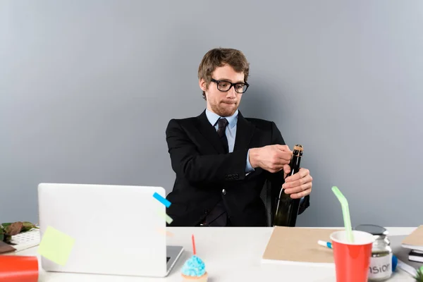 Geschäftsmann Sitzt Arbeitsplatz Und Öffnet Flasche Mit Champagner — Stockfoto