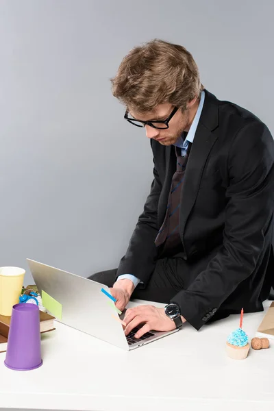 Geschäftsmann Mit Brille Und Laptop Chaotischen Arbeitsplatz Isoliert Auf Grau — Stockfoto