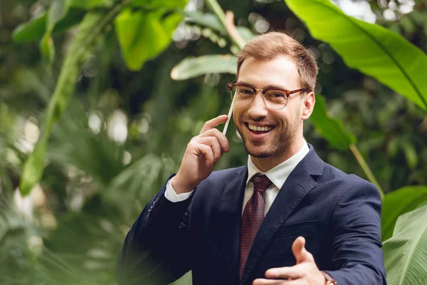 Happy Businessman Suit Tie Glasses Talking Smartphone Greenhouse — Stock Photo, Image