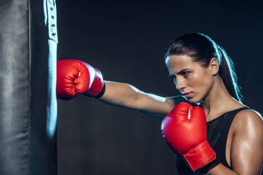 Siyah üzerinde delme çantası ile kırmızı boks eldiven eğitim yorgun boksör