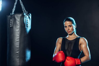Kırmızı eldiven güçlü Boxer delme çantası yakın ayakta ve siyah kamera bakıyor