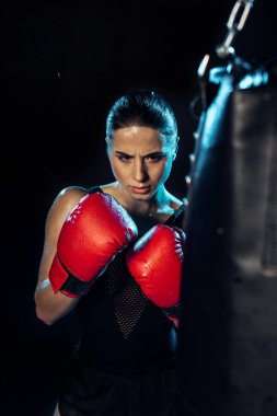 Kırmızı boks eldiven konsantre Boxer siyah üzerinde delme çantası bakıyor