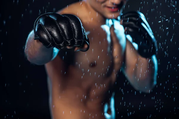 选择性地关注穿着皮手套站在黑色水滴下的拳击手 — 图库照片