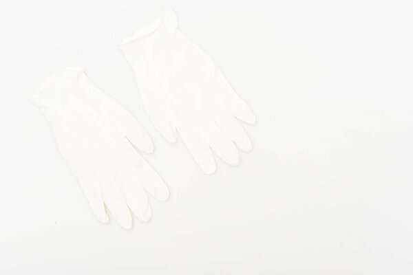 Two white rubber gloves isolated on white surface