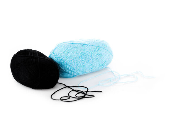 Black and blue yarn clews on white surface