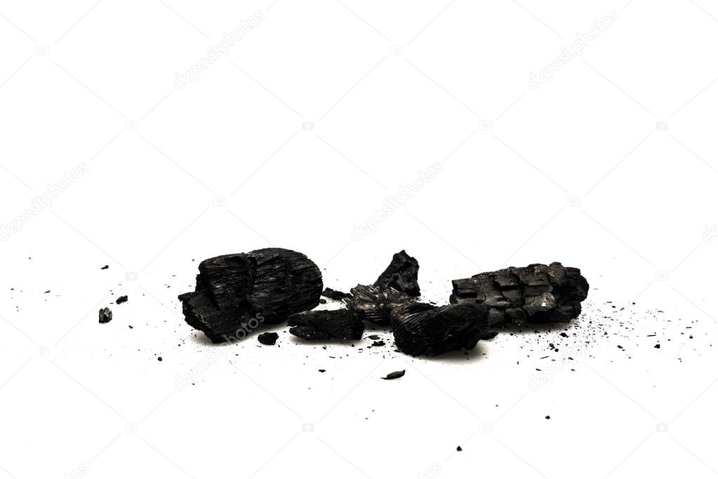 Black burnt firewood with ash on white surface