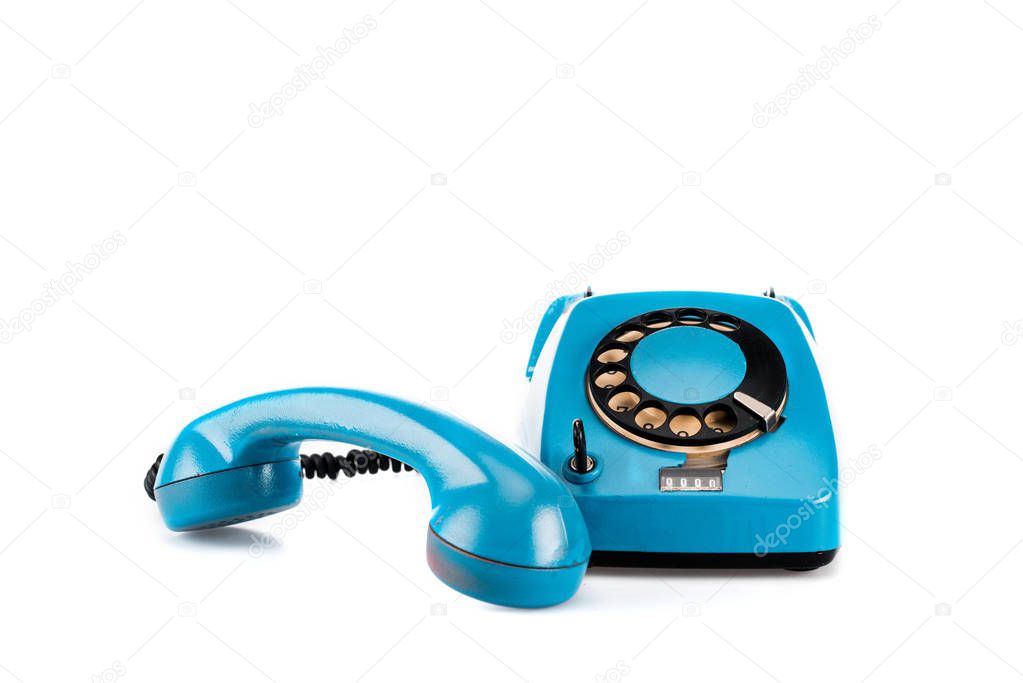 Blue vintage telephone with handset and wire on white