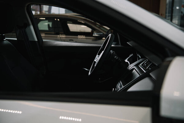 selective focus of black steering wheel in luxury car 