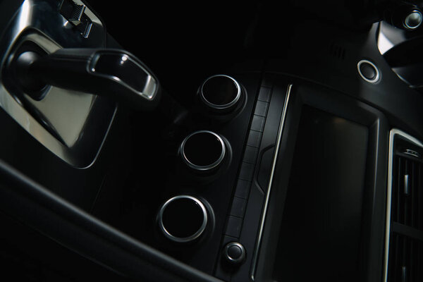 черные кнопки возле современной автомобильной приборной панели и переключение передач в автомобиле
 