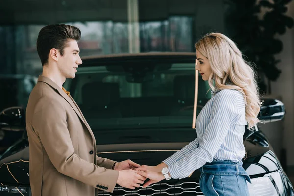 Vacker Man Och Lycklig Blond Kvinna Håller Händer Nära Bil — Stockfoto