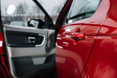 selective focus of shiny car door of red automobile  clipart