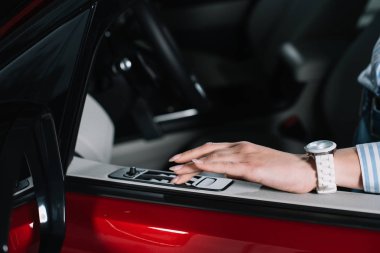 Kırmızı Otomobil araba kapısı üzerinde düğmeye itmek genç kadının kırpılmış görünümü 