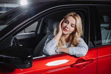 Araba showroom kırmızı otomobil oturan güzel genç kadın  